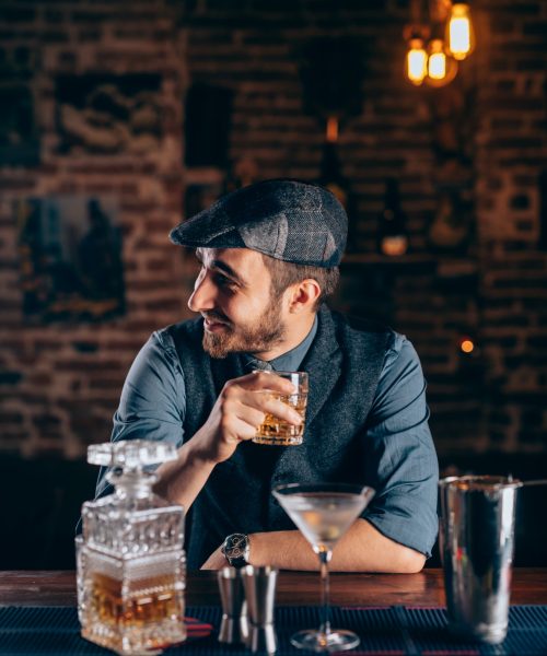 cheerful-bartender-enjoying-an-alcoholic-drink-at-pub-bar-or-restaurant-evening-relaxation-concept.jpg